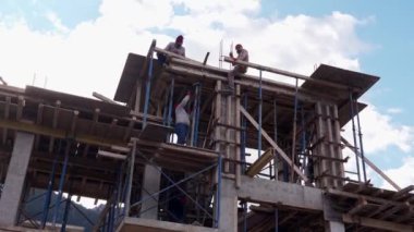 2021-01-17 - Girne, Kuzey Kıbrıs. Kartal Yuvası Villaları inşaat iskelesinde, kırsal alanda. İşçiler dağ köşkü iskeleti inşa ederler. Kereste, beton karışımı, yükseklik çalışması
