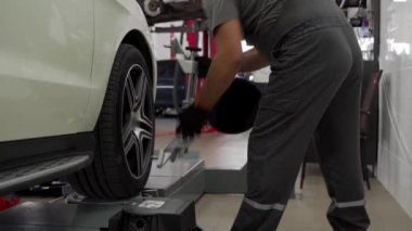 Uygun sürüş için profesyonel teknik servis aracı süspansiyonu. Otomobil tamircisi garajdaki hassas ekipmanlarla araba tekerleği hizasını ayarlar. Bakım, kalibrasyon, ölçüm, otomobil bakımı.