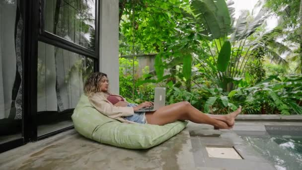 편안한 무성한 여성은 주말에 수영장 노트북으로 휴식을 취합니다 우연한 프리랜서 — 비디오
