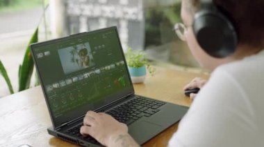 Gündelik kıyafet profesyonelleri görsel efektleri ayarlar, yaratıcı projeler üzerinde çalışır. Transseksüel video düzenleyicisi modern çalışma alanındaki dizüstü bilgisayardan renkli notlar alıyor. Ekrana ve ellere odaklan. Yavaş çekim.