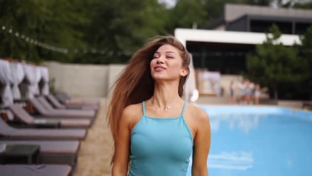 Όμορφη Γυναίκα Θέτει Κοντά Στην Πισίνα Και Ξαπλώστρες Μπλε Φόρεμα — Αρχείο Βίντεο
