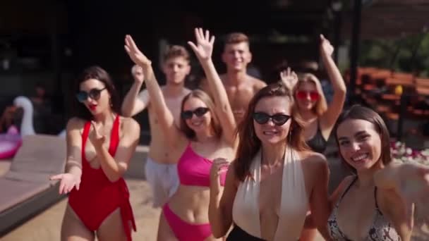 一群穿着五颜六色比基尼的朋友参加了夏季派对 在豪华俱乐部室外露台的游泳池边散步 身着泳衣的男女将在海滨度假胜地度假 — 图库视频影像