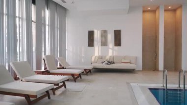 Lüks bir eğlence alanı, büyük pencereler, gün ışığında minimalist dekorasyon. Boş modern kapalı havuzlu güneşli yatak odası. Lüks kaplıcalarda rahatlama kavramı.