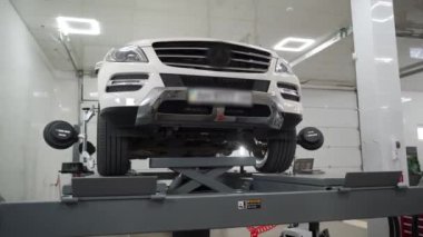 Araç tam kalibrasyon için kaldırıldı, bakım servisi sırasında modern garajda sensörlerle donatıldı. Profesyonel tamirci oto tamirhanesinde SUV 'nin tekerlek hizasını ayarladı.