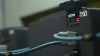 2021-09-23 - Mariupol, Ukrane. Magma fabrikası. Elektrikçi, kontrol kabinesini ayarlar, kontrol cihazını otomasyon sistemine bağlar, endüstriyel tesislerde mavi üniforma giyer..