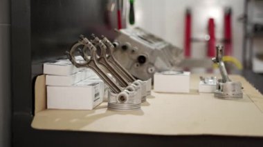 Tamirciler araç performansını artırmak için parçaları değiştiriyor. Silindir başı ve pistonlar da dahil olmak üzere otomotiv motor bakım kiti görüntülendi. Profesyonel onarım, bakım yakalanan atölye.