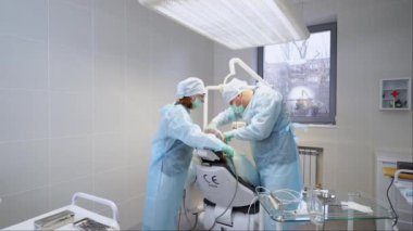 Diş implantı ameliyatı. Modern diş kliniğinde kök kanallarını tedavi eden ağız cerrahı ve asistan. Endodontist hemşire tarafından ameliyat edildi. Stomatolojistin konsantre çalışması.