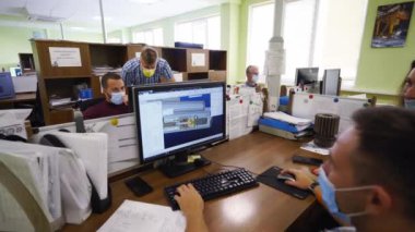 2021-09-23 - Mariupol, Ukrane. Magma fabrikası. Kadın profesyonel, erkek meslektaşıyla bilgisayar başında CAD planlarını tartışıyor. Çeşitli takım mühendisleri ofis ortamında proje üzerinde işbirliği yapıyor.