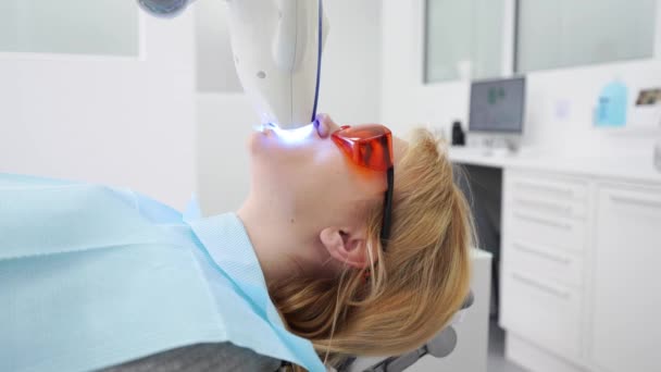 Zbliżenie Kobiecej Twarzy Pacjenta Podczas Zabiegu Wybielania Zębów Nowoczesnym Gabinecie — Wideo stockowe