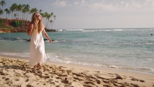 Γυναίκα Λευκό Φόρεμα Απολαμβάνει Παγωτό Χωνάκι Στην Τροπική Παραλία Βόλτα — Αρχείο Βίντεο