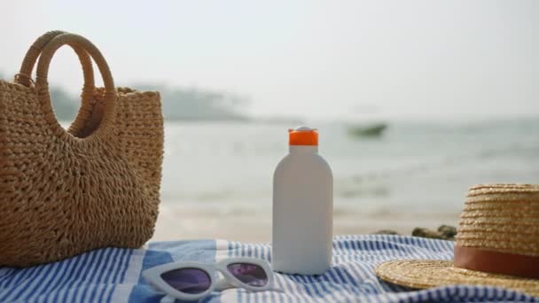 紫外线防御的基本要素 确保无忧无虑的度假氛围 清澈的天空下 海滩边的草袋 日光浴 太阳镜和带条纹毛巾上的帽子 — 图库视频影像