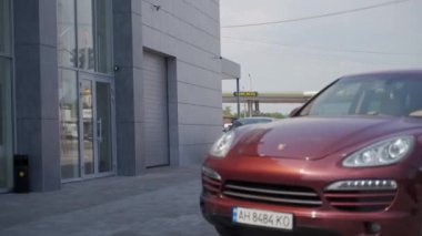 2020-07-02 - Mariupol, Ukrayna. Uçak Araba Servisi. Lüks araç bakım ve onarım için garaja yaklaşıyor. Kırmızı SUV gündüz vakti otomobil servis istasyonuna giriyor. Sürücü mekanik atölyesini ziyaret etti.
