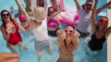 Erkek arkadaşlar ve kız arkadaşlar lüks kulüpteki havuz partisinde yaz havasının tadını çıkarıyorlar. Erkekler ve kadınlar gülümser, el sallar, dalarlar ve turkuaz berrak suda yüzerler. Arkadaşlarla sıcak tatilde gürültülü bir kutlama.