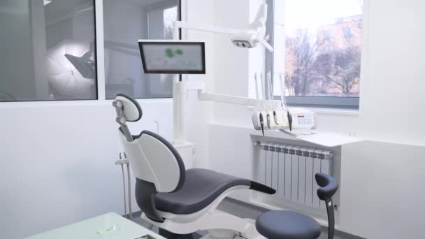 専門の現代装置が付いている物質学のオフィスの歯科椅子 現代的な椅子および特別な歯科装置が付いている歯科医のオフィスの内部 現代歯科クリニック ストマトロジー — ストック動画