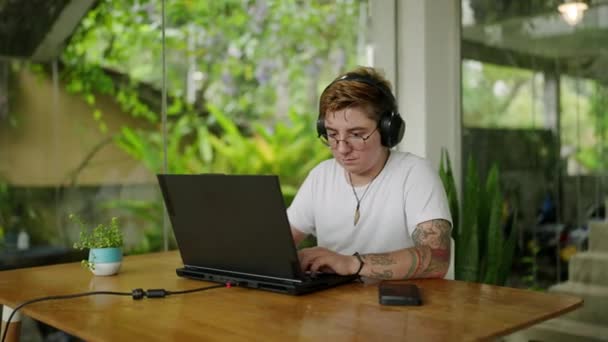 Kulaklıklar Takılı Odaklanmış Dövmeli Yemyeşil Ortamda Dijital Göçebe Yaşam Tarzını — Stok video