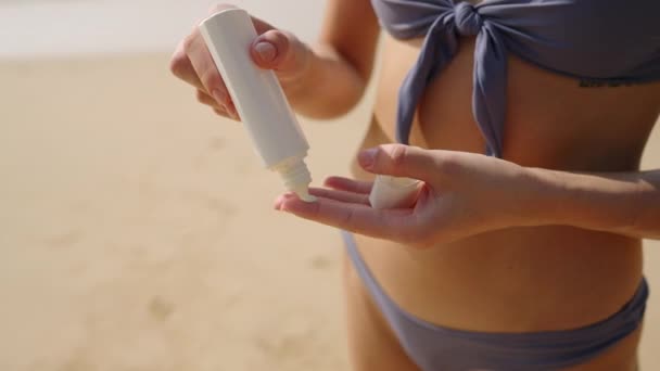 Kobiece Ręce Wyciskające Krem Opalania Butelki Nakładające Dłoń Piaszczystej Plaży — Wideo stockowe