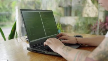 Odaklanma değişimleri, açık hava kodlama sahneleri, parmak uçlarında yenilik. Yazılım geliştiricisi dizüstü bilgisayardaki kodları doğal ışıkla kodlar, parmaklar tuşların üzerinde uçar, ekran programlama sözdizimiyle doludur. Yavaşla