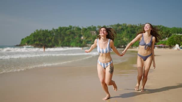 Šťastné Dívky Bikinách Drží Ruce Běží Písečné Pláži Tropickém Ostrově — Stock video