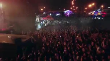 2021-08-08 - Mariupol Şehir Festivali, Ukrayna. Hayranlar dans eder, gece sahne ışıkları altında tezahürat yapar. Hava görüntüleri, açık hava müzik festivalinde kalabalığı canlı yakalıyor. Etkinlik mekanda, taraftarlar konserin keyfini çıkarıyor.