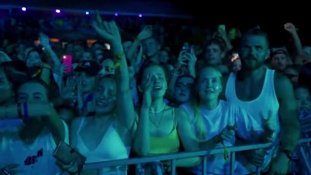 2021 ウクライナ マリポール シティ フェスティバル ファンはライブコンサートを楽しみ ネオンライトは顔を照らします ナイトミュージックフェスティバルでエネルギッシュな群衆が踊ります 友達がセルフィーを撮り ステージパフォーマンスに興奮する — ストック動画