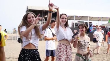 2021-08-06 - Mariupol Şehir Festivali, Ukrayna. Kalabalık canlı orkestrayı, plaj partisi havasını seviyor. Arkadaşlar deniz kenarındaki müzik festivalinde dans eder, kızlar gülümser, selfie çeker. Enerjik gençlik havası, kıyı olayı.