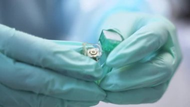 Diş implantının diş hekimlerinin eline yakın plan görüntüsü. Ağız cerrahı modern diş kliniğinde titanyum implant gösteriyor. İmplantasyon ameliyatı yapılıyor. Dişçi titanyum yerleştirme.