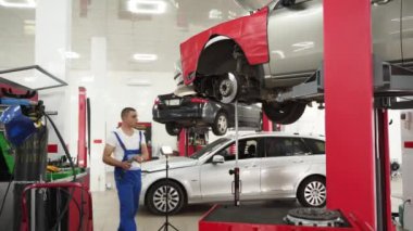 Uzman vites kutusunu tamir eder, basınç plakası, disk, fırlatma yatağı kurar. Modern araba atölyesindeki oto tamircisi debriyajı değiştirdi. Araç bakımı, garajdaki iletim servisi..