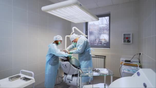 在现代医疗诊所安装假牙的口腔外科医生和辅助人员 牙科植入术 去除神经 牙科医生和护士治疗病人的根管 内窥镜 — 图库视频影像