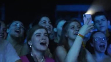 2021-08-06 - Mariupol Şehir Festivali, Ukrayna. Bulanık ışıklar, sahne hareketli parti ortamı yaratır. Gece müzik festivalindeki enerjik kalabalık, dans, tezahürat, akıllı telefonlarla selfie çekmek..