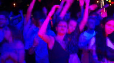 2021-08-07 - Mariupol Şehir Festivali, Ukrayna. Heyecanlı izleyiciler canlı müzikten hoşlanır, el sallayarak ritim tuttururlar. Gece festivalindeki enerjik kalabalık sahne ışıkları altında dans ediyor.