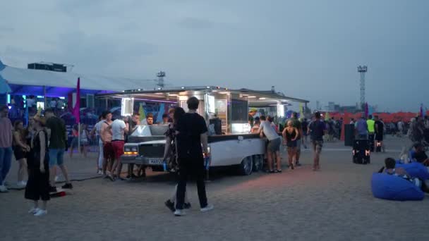 2021 07年 乌克兰Mariupol City Festival 复古汽车变成了有灯光的移动厨房 人们排队购买小吃 海滩音乐节的食品卡车在晚上为客人提供服务 — 图库视频影像