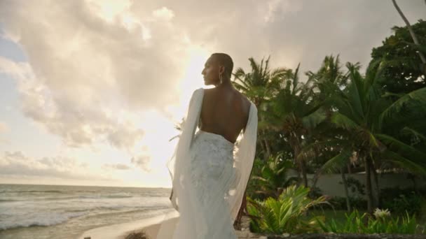 드레스를 비이진 모델은 일몰에 근처의 해변에서 포즈를 취합니다 색깔의 안드로기노스 — 비디오