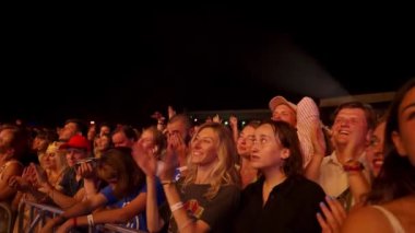 2021-08-06 - Mariupol Şehir Festivali, Ukrayna. Hayranlar alkışlar, sahne ışıkları. Gece müzik festivalinde enerjik kalabalık dans ediyor. Heyecanlı grup konserin tadını çıkarıyor. Gençler açık hava olayını kutluyor.