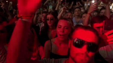 2021-08-06 - Mariupol Şehir Festivali, Ukrayna. Eller havada, konser akıllı telefonları çeken hayranlar. Müzik festivali geceleri dans ediyor. Heyecanlı izleyiciler açık havada grup performansını seviyor.