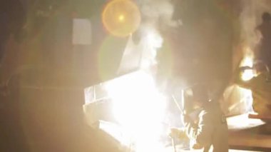 2013-12-15 - Mariupol, Ukrayna. Azov Tersanesi. Koruyucu teçhizat kullanan endüstriyel işçiler fabrika ortamında metal kaynak yapıyorlar. Kaynakçılar parçalarını birleştirirken kıvılcımlar uçuşur, duman yükselir. El emeği ve metal işçiliği.