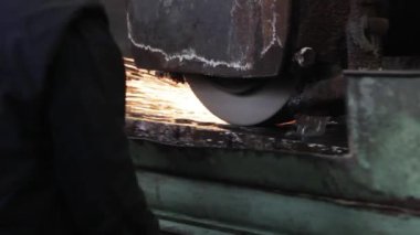 2013-12-01 - Mariupol, Ukrayna. Azov gemi tamirhanesi. Fabrikada öğütücüyle metal işi. Sanayi işçisi kıvılcımlar saçan çelik parçaları öğütüyor. Koruyucu dişli makinist metali işliyor.