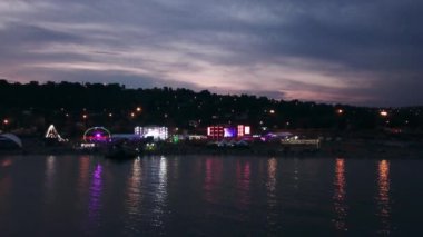 2021-08-08 - Mariupol Şehir Festivali, Ukrayna. Hava akşam manzaralı canlı müzik festivali. Deniz sahneleri aydınlandı, kalabalıklar kıyı olaylarını, canlı atmosferi, çadırları, karanlık gökyüzünü sardı..