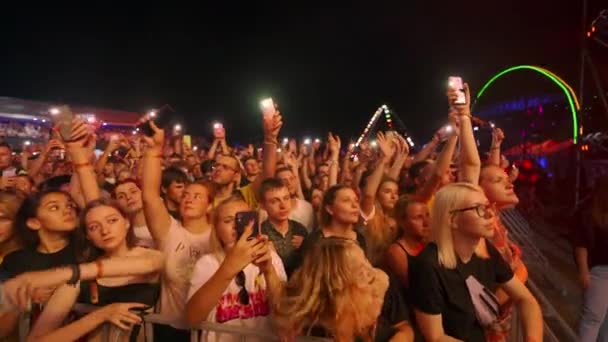 2021 マリポルシティフェスティバル ウクライナ ライト付きファンウェーブ携帯電話 ライブパフォーマンスにダンス クラウドは音楽祭で夜のコンサートを楽しんでいる アウトドアサマーイベントで感動的な観客 — ストック動画