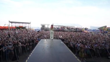 2021-08-08 - Mariupol Şehir Festivali, Ukrayna. Hayranlar tezahürat yapıyor, müzik festivaline atlıyor, günbatımı arka planında. Kis Kis grubunun canlı performansı, dinamik solistin dinamik dinleyici kitlesi ile canlı sahne.