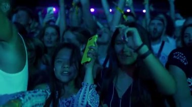 2021-08-06 - Mariupol Şehir Festivali, Ukrayna. Genç yetişkinler konserden, akıllı telefonlardan anları yakalamaktan, festival atmosferinden hoşlanırlar. Müzik festivali kalabalığı gece sahne ışıkları altında heyecanla dans ediyor..