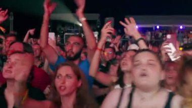 2021-08-06 - Mariupol Şehir Festivali, Ukrayna. Cep telefonları konser anlarını kaydediyor, insanlar parti atmosferini seviyor. Gece müzik festivalinde enerjik kalabalık, hayranlar dans ediyor, sahne ışıkları altında tezahürat yapıyorlar..