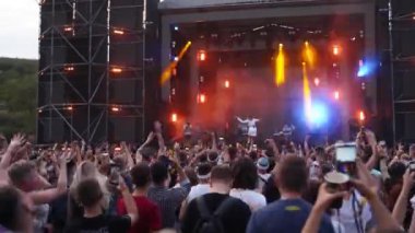 2021-08-07 - Mariupol Şehir Festivali, Ukrayna. Cream Soda grubunun konser sahnesindeki canlı performansı, coşkulu ışık şovu seyirciyi heyecanlandırıyor. Müzisyenler el sallıyor. Açık hava etkinliği hayranlarına bağlanıyor..