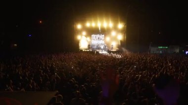 2021-08-08 - Mariupol Şehir Festivali, Ukrayna. Konserden hoşlanan kalabalık, canlı ışıklarla aydınlatılmış sahne, el sallayan pervaneler, açık hava enerjisi. Müzik grubu Pornofilmler gece festivalinde canlı performans sergiliyor.