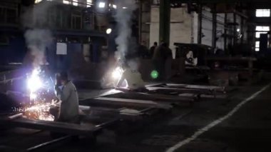 2013-12-15 - Mariupol, Ukrayna. Azov Tersanesi. Koruyucu teçhizat üreticisi metal parçalarına katılıyor. Fabrika çalışmaları sırasında kıvılcımlar uçuşuyor. Üretim süreci, bir fabrikada metal işi..