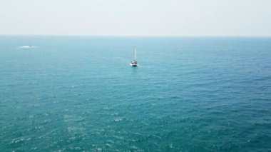 2023-03-15 - Mirissa Körfezi, Sri Lanka. Yelkenli geniş mavi okyanusta yol alır, hava manzarası deniz kenarında tropik sahil maceralarını yakalar..