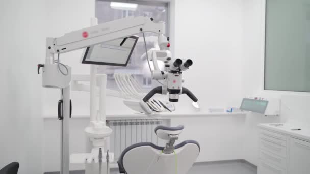 現代歯科オフィスの回転式双眼鏡を備えた歯科顕微鏡 患者の歯を治療するための歯科顕微鏡を使用します 歯科クリニックの専門機器 歯の顕微鏡と義肢について — ストック動画