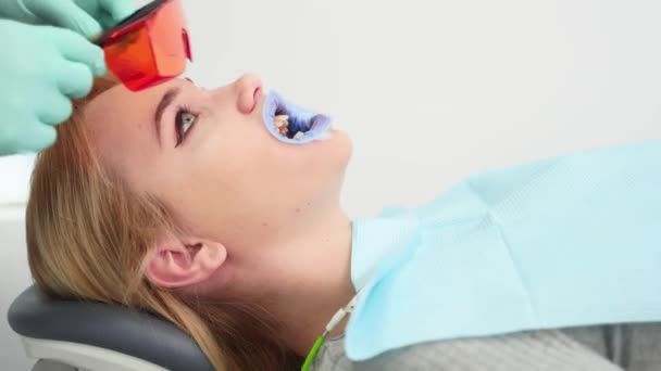 Οδοντίατροι Χέρια Βάζει Προστατευτικά Κόκκινα Γυαλιά Γυναίκες Ασθενείς Πρόσωπο Πριν — Αρχείο Βίντεο