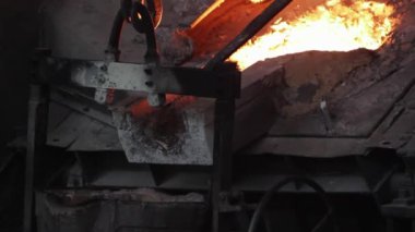 Ağır endüstri üretim süreci, aşırı ısı, kıvılcımlar uçuşuyor. Endüstriyel dökümhane çelik döküm, erimiş metal kepçeden küfe dökülmüş. Metalürji, mühendislik ve ekipman fabrikada çalışıyor.