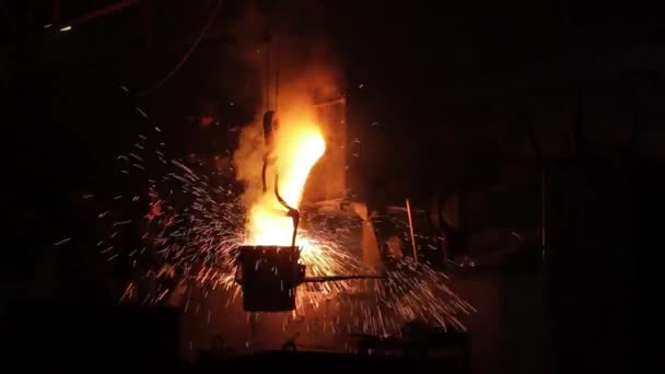 生产厂的工业铸钢工艺显示 钢包内的熔融金属喷射 铸造厂工人监督精密冶金操作 火花在黑暗的工厂环境中四处飞扬 — 图库视频影像