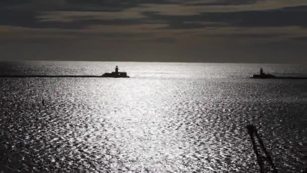 Silhouetted Vuurtorens Staan Wacht Steigers Glinsterende Oceaan Reflecteert Zonlicht Serene — Stockvideo